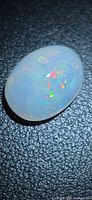 Top view of oval opal showing multicolour flashes