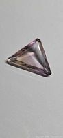 Triangular faceted ametrine showing purple and golden hues