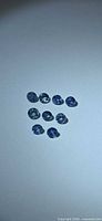 Group of nine round blue sapphires on neutral background