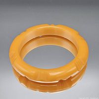 Top view of orange carved resin bangle bracelet