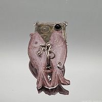 Front view showing carved double fish and sterling mount