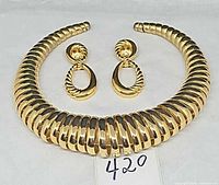 Choker necklace and earrings laid flat on white background