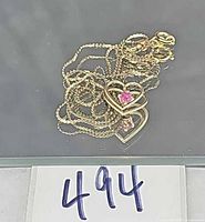 Pendant necklace coiled showing heart pendant with red stone