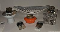 Group shot showing all five lighters and Haeger ashtray