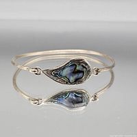 Full view of silver-tone bangle bracelet showing teardrop abalone centerpiece and overall condition