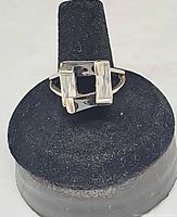 Front view of ring on display stand showing geometric stone arrangement