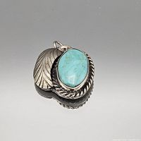 Front view showing turquoise cabochon, rope bezel and leaf motif