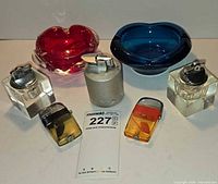 Group shot of all items: two ashtrays, five lighters