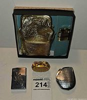 Overview of boxed cigarette case with lighter plus three additional lighters