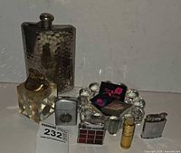 Group shot showing all items: flask, six lighters, ashtray, matchbooks