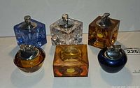 Group shot of five glass lighters and amber ashtray