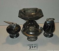 Group view of three table lighters and one ashtray