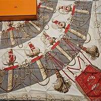 Full scarf laid out with partial view of orange Hermès box