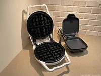 Open Belgian waffle maker next to open Dash omelette maker