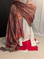 Full view of scarf draped to show pattern, colours, tassels