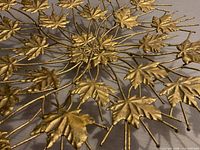oblique close-up of gold metal maple leaves and wire structure