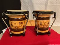 Front view of attached bongos showing wood shells, metal hardware, skin heads