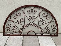 Front view of semicircular metal scrollwork panel