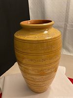 Full view of yellow ceramic vase showing overall form and decorative bands