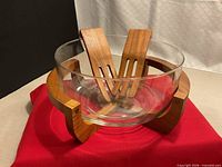 assembled set showing glass bowl seated in teak holder with claws inside