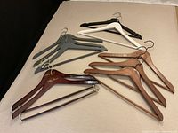 Assortment of ten wooden hangers in various finishes laid out
