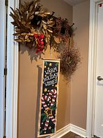 All three wreaths and scroll hanging on wall