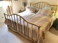 Front view of king brass bed with headboard and footboard
