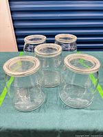 Five clear glass storage jars displayed together