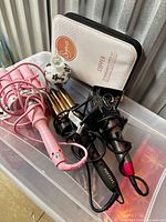 Group shot of waver, curling iron, brush case and ceramic jar