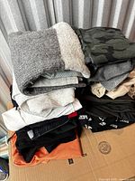 Stack of folded garments on box showing variety of colours and textures