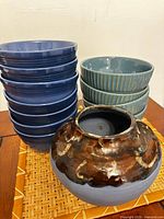 Stack of navy blue bowls, stack of blue-green bowls, decorative pot grouped on tray