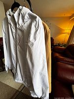 White ZeroXposur hooded windbreaker front view with tan parka behind