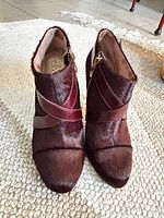 Front view showing pair of burgundy haircalf ankle booties with cross straps and side zippers