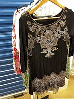 Black embellished tunic front, additional garments behind