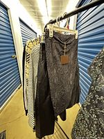 Rack view showing three skirts: snakeskin print, black faux leather, black lace-hem