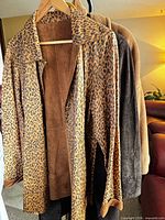 Three coats on hanger: leopard reversible, brown suede, grey wool.