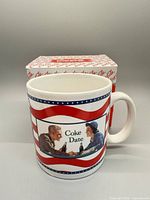 mug front view showing 'Coke Date' graphic, box behind