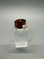 Front angle of copper adjustable ring showing engraved motif