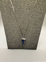 Full view of necklace on display stand showing entire chain and pendant