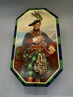 Lid view showing Highlander image and tartan border