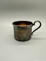 Side view of small EP copper cup showing tarnished exterior and handle