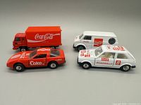 All four Coca-Cola die-cast vehicles displayed side by side