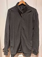 Front view of charcoal grey full-zip sweater on hanger