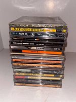Stack of sealed CDs showing spines with readable titles