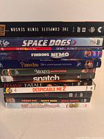 Stack of 13 DVDs showing titles from Stargate SG-1 to The Muppets Christmas Movie