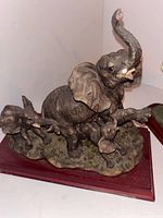 Adult and calf elephant sculpture on wood base