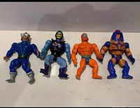 Four MOTU figures lying flat