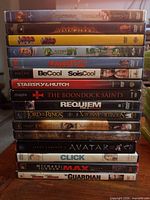 Stack of 15 DVD movie cases showing titles and spine wear