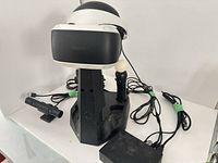 Headset on charging stand with one Move controller and cables visible