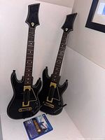 Two black Guitar Hero Live guitars and PS4 game case overview